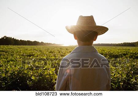 Stock Image - Caucasian boy overlooking rural field. Fotosearch