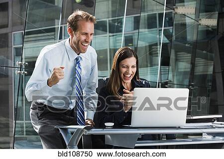Caucasian business people cheering at laptop View Large Photo Image Stock Image - Caucasian business people cheering at laptop. Fotosearch