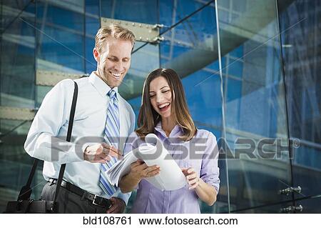 Stock Image - Caucasian business people talking in office. Fotosearch