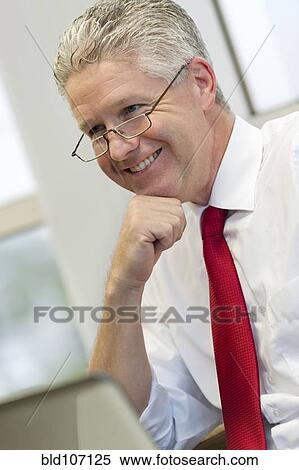 Stock Photography - Caucasian businessman sitting at desk. Fotosearch