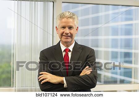 Picture - Caucasian businessman standing in office. Fotosearch