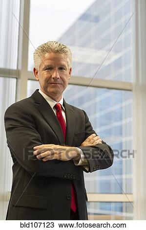 Stock Image - Caucasian businessman standing in office. Fotosearch