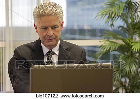 Caucasian businessman working on laptop View Large Photo Image Stock Image - Caucasian businessman working on laptop. Fotosearch