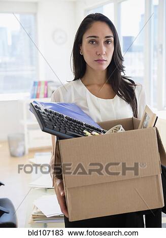 Stock Image - Caucasian businesswoman carrying personal items. Fotosearch