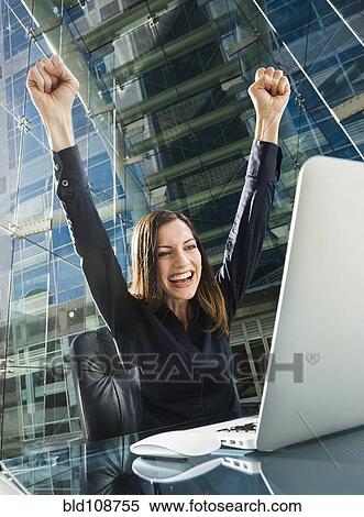 Caucasian businesswoman cheering at computer View Large Photo Image Stock Photography - Caucasian businesswoman cheering at computer. Fotosearch