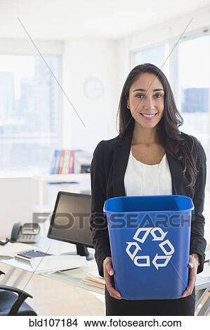 Picture - Caucasian businesswoman holding recycle bin. Fotosearch