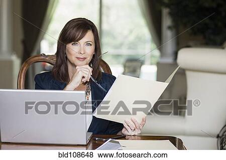 Caucasian businesswoman looking at paperwork View Large Photo Image Stock Photo - Caucasian businesswoman looking at paperwork. Fotosearch
