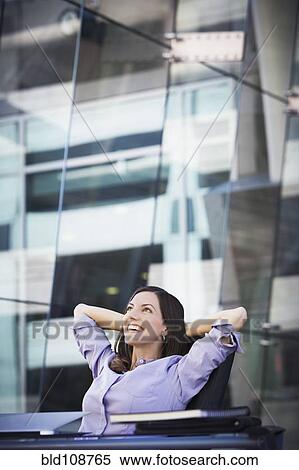 Stock Photography - Caucasian businesswoman relaxing at desk. Fotosearch