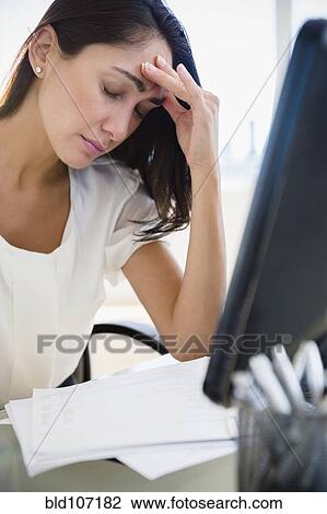Caucasian businesswoman rubbing forehead at desk View Large Photo Image Stock Image - Caucasian businesswoman rubbing forehead at desk. Fotosearch
