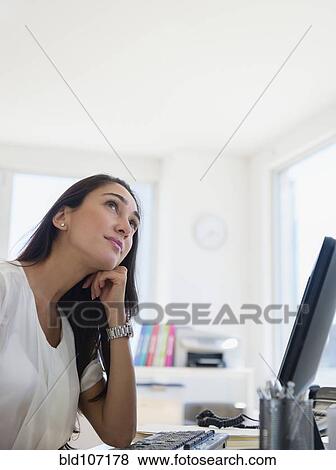 Caucasian businesswoman sitting at desk View Large Photo Image Stock Photo - Caucasian businesswoman sitting at desk. Fotosearch