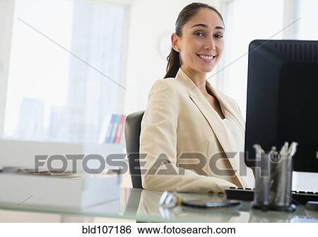 Caucasian businesswoman sitting at desk View Large Photo Image Stock Photograph - Caucasian businesswoman sitting at desk. Fotosearch