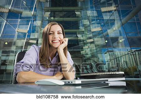 Caucasian businesswoman smiling at desk View Large Photo Image Stock Photo - Caucasian businesswoman smiling at desk. Fotosearch