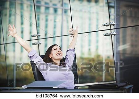 Picture - Caucasian businesswoman stretching at desk. Fotosearch