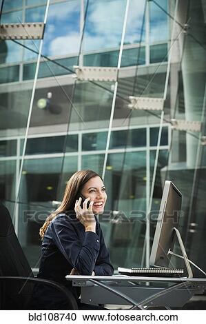 Stock Image - Caucasian businesswoman talking on cell phone. Fotosearch