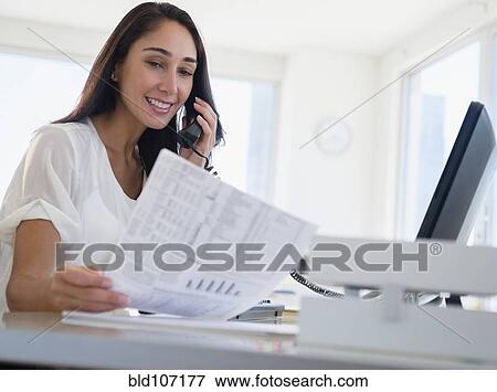 Stock Photo - Caucasian businesswoman working at desk. Fotosearch