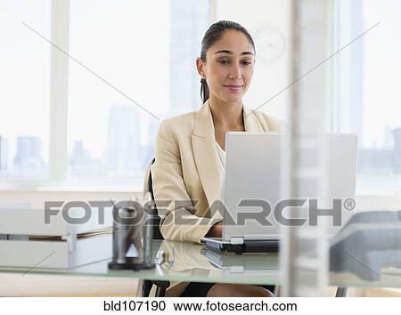 Stock Image - Caucasian businesswoman working on laptop. Fotosearch