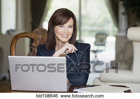 Stock Photograph - Caucasian businesswoman working on laptop. Fotosearch