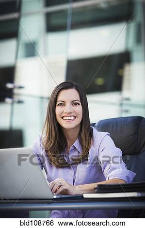 Stock Photograph - Caucasian businesswoman working on laptop. Fotosearch