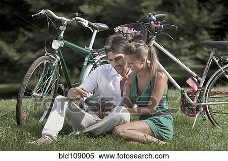 Caucasian couple reading book in grass View Large Photo Image Stock Photography - Caucasian couple reading book in grass. Fotosearch