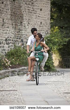 Stock Photo - Caucasian couple riding bicycle together. Fotosearch