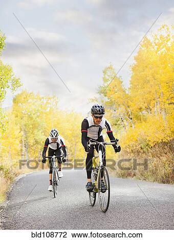 Stock Image - Caucasian cyclists on rural road. Fotosearch
