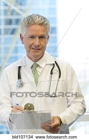 Picture - Caucasian doctor holding clipboard. Fotosearch