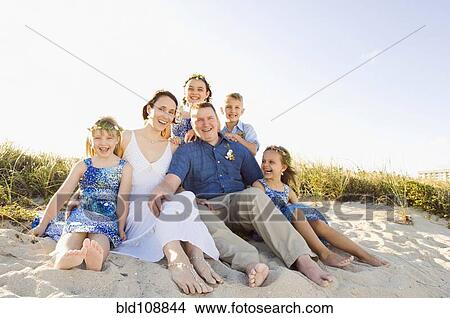 Picture - Caucasian family sitting together on beach. Fotosearch