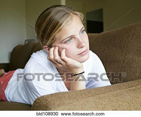 Stock Image - Caucasian girl laying on sofa. Fotosearch