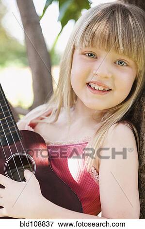 Caucasian girl playing ukulele in tree View Large Photo Image Stock Photo - Caucasian girl playing ukulele in tree. Fotosearch