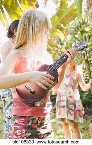 Caucasian girl playing ukulele outdoors View Large Photo Image Stock Image - Caucasian girl playing ukulele outdoors. Fotosearch