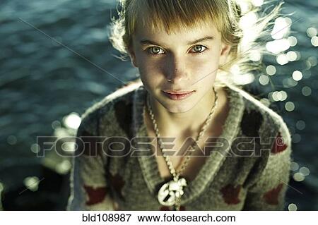 Stock Photo - Caucasian girl sitting by water. Fotosearch