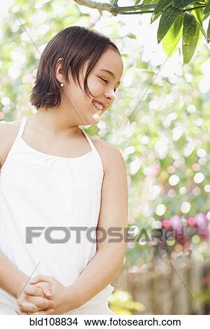 Picture - Caucasian girl standing outdoors. Fotosearch
