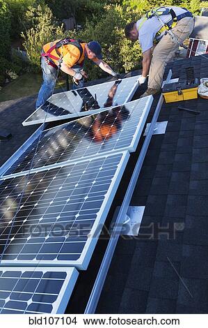 Caucasian men installing panels on roof View Large Photo Image Picture - Caucasian men installing panels on roof. Fotosearch