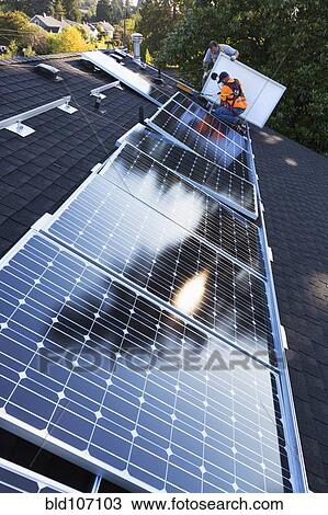Caucasian men installing panels on roof View Large Photo Image Stock Image - Caucasian men installing panels on roof. Fotosearch