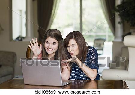 Caucasian mother and daughter having video chat on laptop View Large Photo Image Stock Photo - Caucasian mother and daughter having video chat on laptop. Fotosearch