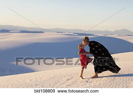 Stock Photo - Caucasian mother and daughter kissing in desert. Fotosearch