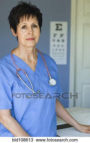 Stock Image - Caucasian nurse standing in doctor's office. Fotosearch