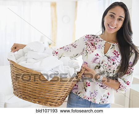 Caucasian woman carrying basket of laundry View Large Photo Image Stock Image - Caucasian woman carrying basket of laundry. Fotosearch
