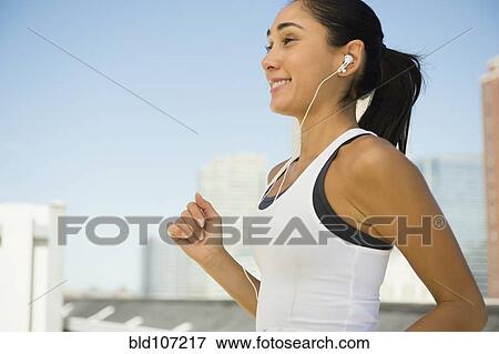 Stock Photo - Caucasian woman jogging with earphones. Fotosearch