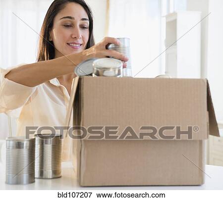 Stock Photo - Caucasian woman recycling cans. Fotosearch