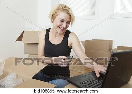Caucasian woman shopping online in new home View Large Photo Image Stock Photography - Caucasian woman shopping online in new home. Fotosearch
