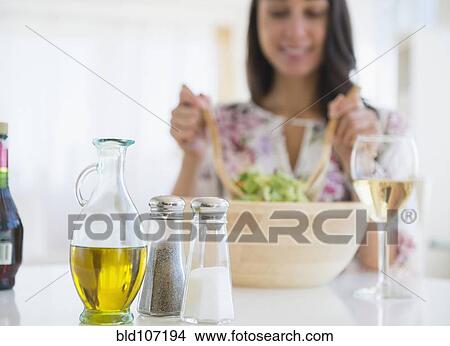 Picture - Caucasian woman tossing salad at lunch. Fotosearch
