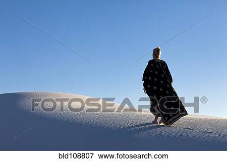 Stock Photo - Caucasian woman walking in desert. Fotosearch