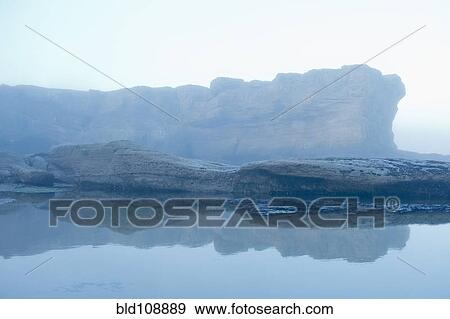 Stock Photo - Cliffs on foggy coastline. Fotosearch