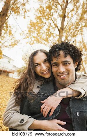 Couple hugging in autumn leaves View Large Photo Image Stock Photo - Couple hugging in autumn leaves. Fotosearch