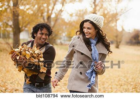 Picture - Couple playing in autumn leaves. Fotosearch