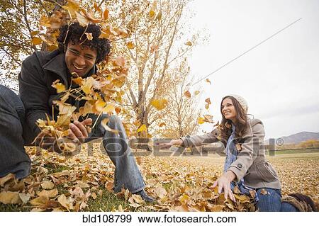 Couple playing in autumn leaves View Large Photo Image Stock Photo - Couple playing in autumn leaves. Fotosearch