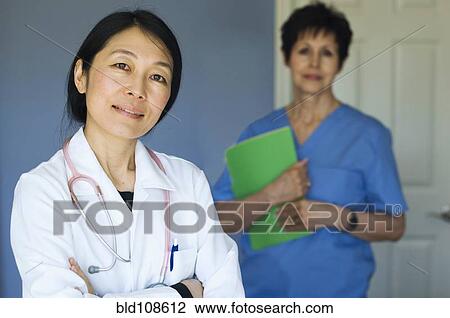 Doctor and nurse standing in office View Large Photo Image Stock Image - Doctor and nurse standing in office. Fotosearch