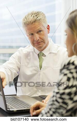 Stock Image - Doctor and patient talking in office. Fotosearch