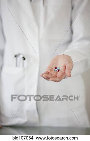 Picture - Doctor holding handful of pills. Fotosearch